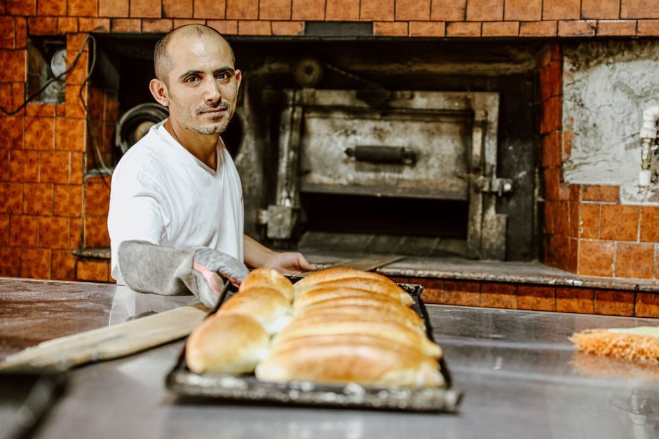 Panadero sacando bollitos del horno